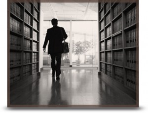 A man walking between bookshelves